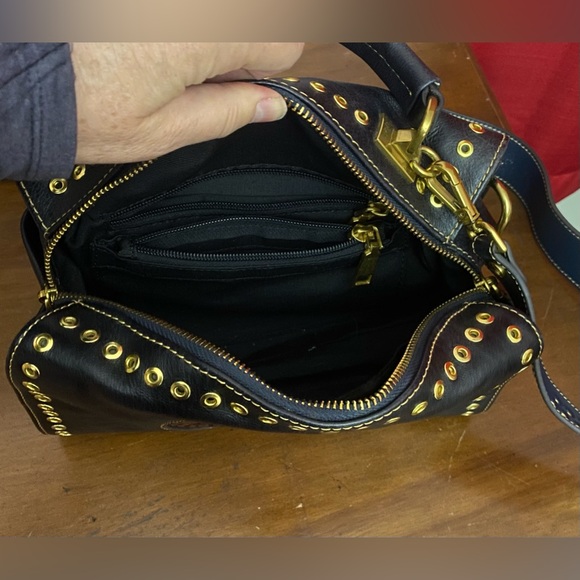 Black leather cross body purse with orange colored medallion on front. - Picture 7 of 14